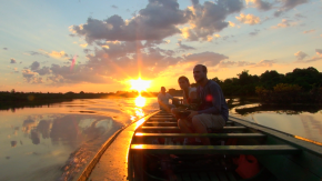 expedicionários durante o pôr do sol em barco na amazônia
