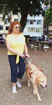 Deborah Prates na rua com seu cão-guia