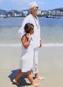 Fernanda Honorato e pai Luiz do Sol caminham pela praia da Urca.