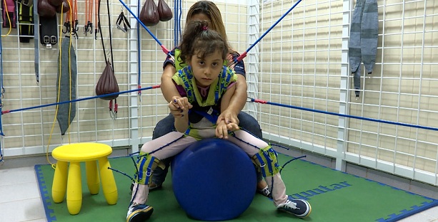 Criança usa o PediaSuit em sessão de terapia ocupacional.