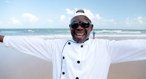 O nigeriano Ezequiel serve "fufu" – prato típico de sua terra natal – na praia de Boa Viagem, Recife.