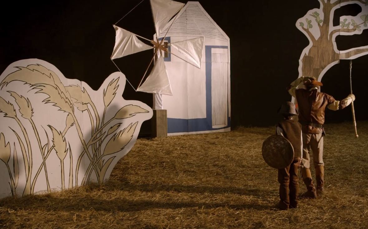 Cenário com moinho de vento, um cavaleiro e seu escudeiro, como no livro Dom Quixote